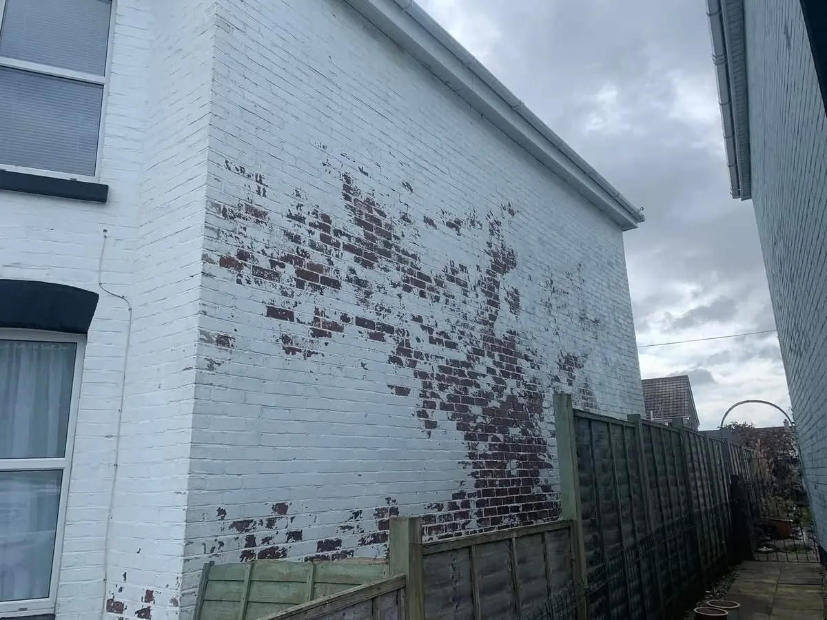 Peeling paint on a brick wall before redecoration in Bodmin